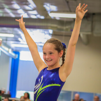 Maximum Athlete salutes the judges after finishing her routine at Skills Meet.