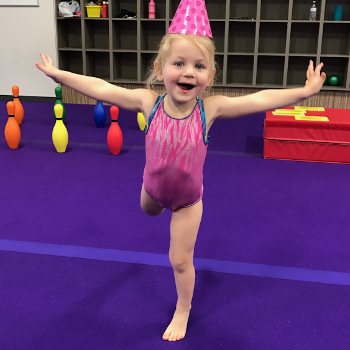 Gymnast attempts an arabesque at a birthday party.
